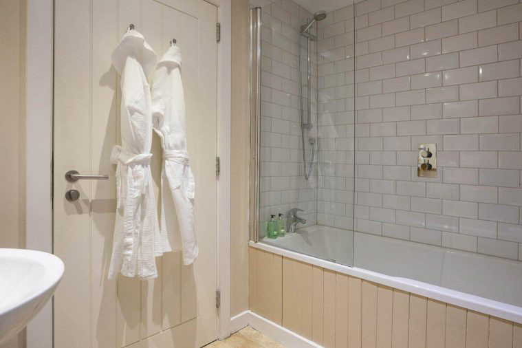 Ensuite bathroom with two complementary robes hanging on the door