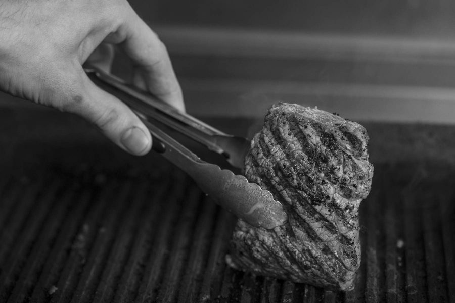 A steak being seared on a grill